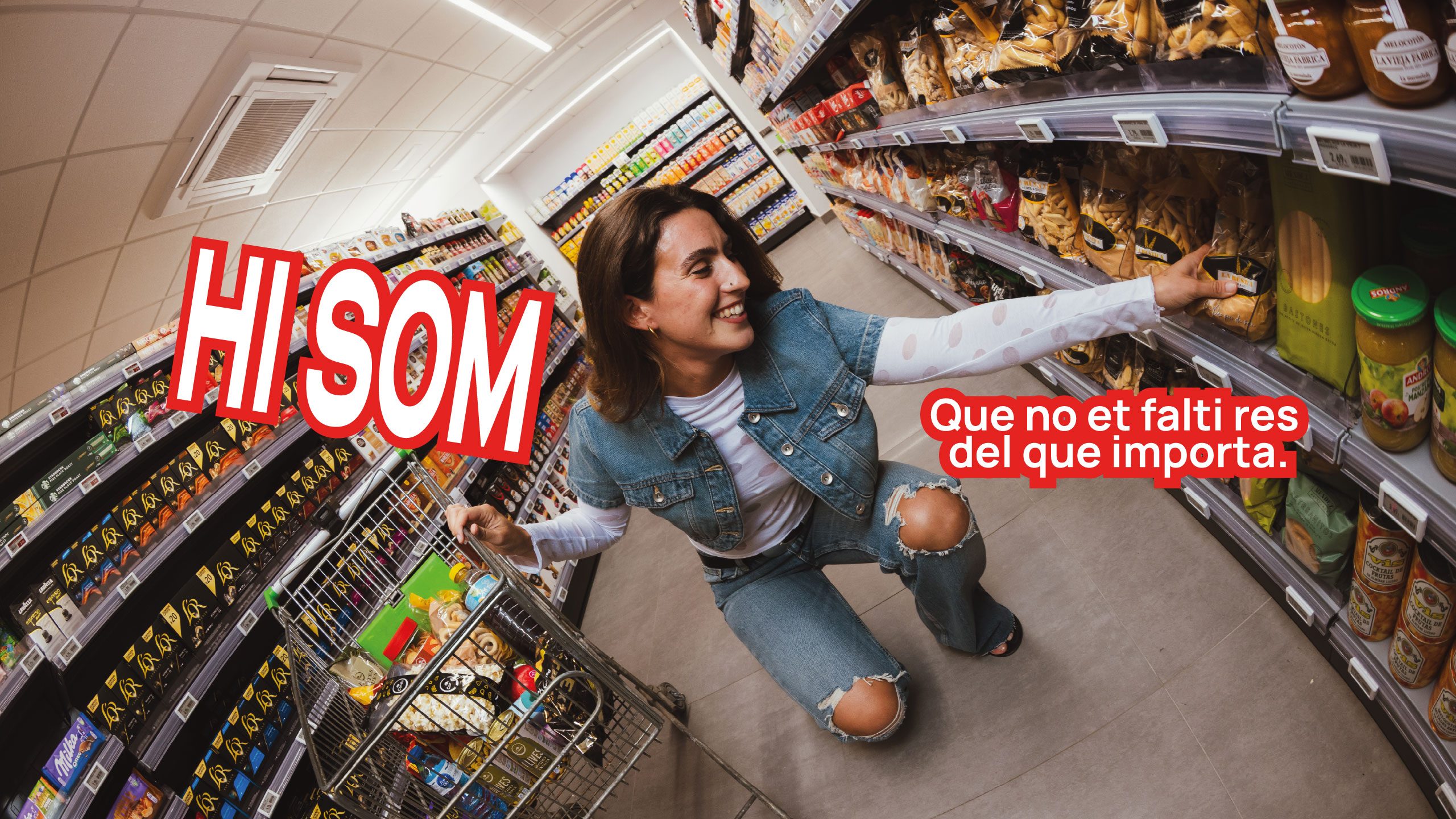 Una clienta sonriente en un pasillo de un supermercado Condis, con el lema HI SOM: Que no et falti res del que importa.